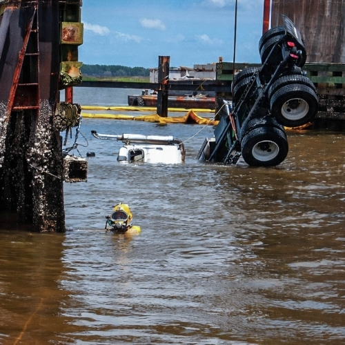 Commercial diver assisting with submerged vehicle recovery