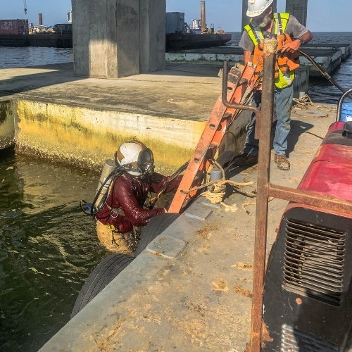 Commercial diving crew supporting a dock inspection