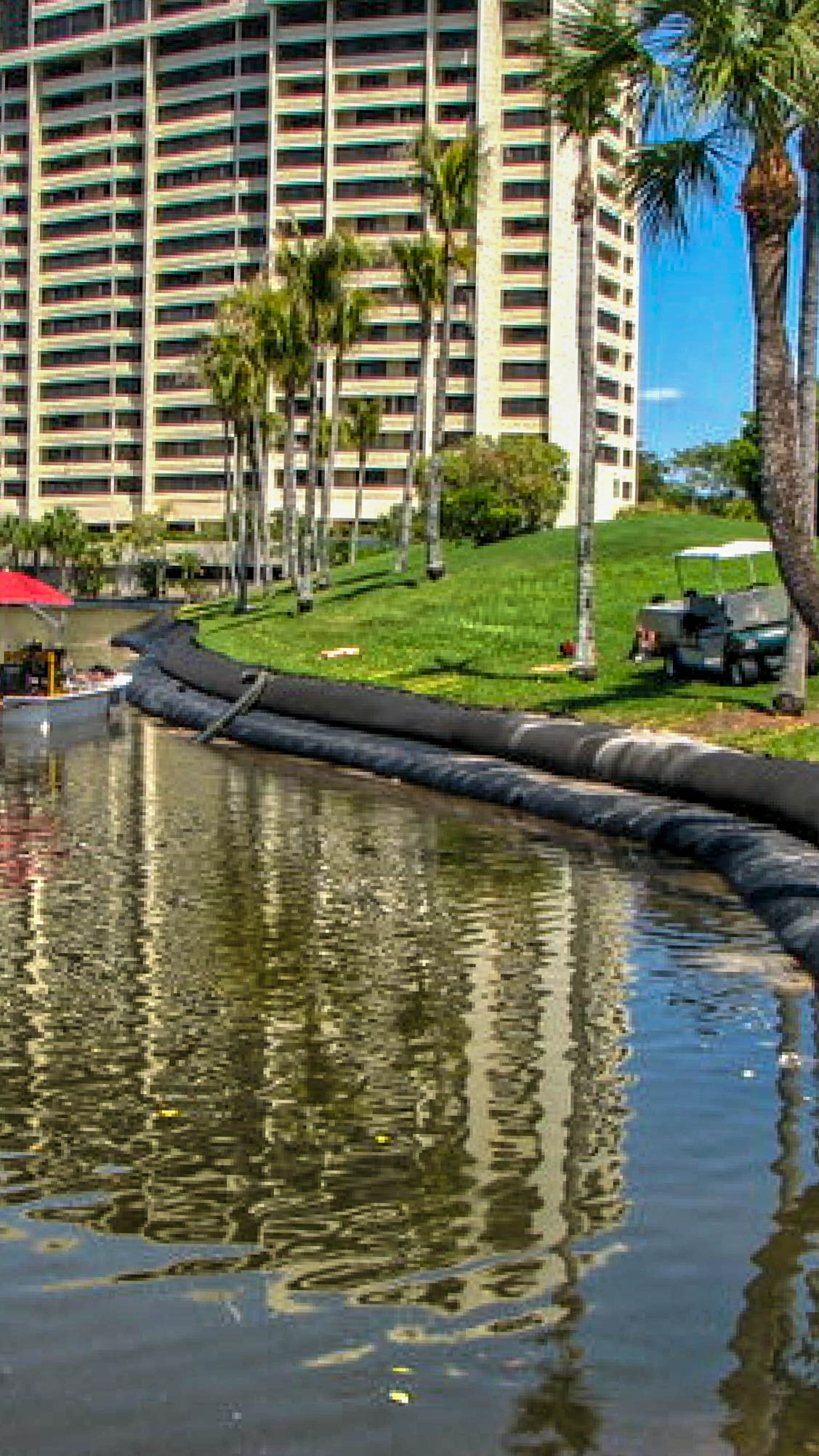 Tall high-rise tower above a newly placed Geo Tube canal bank during installation