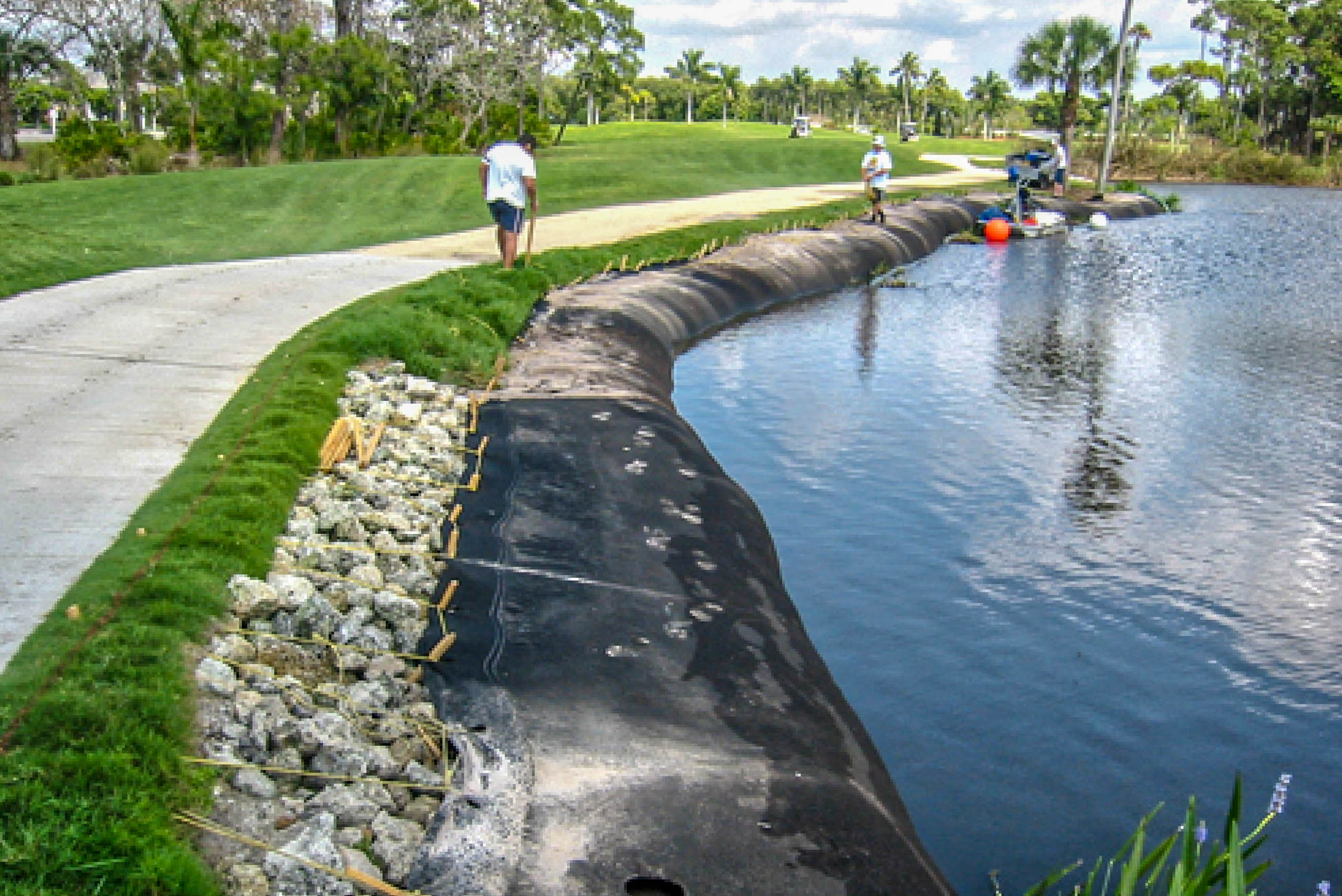 Crew installing rip-rap along a Geo Tube curve on the Windstar Golf Course
