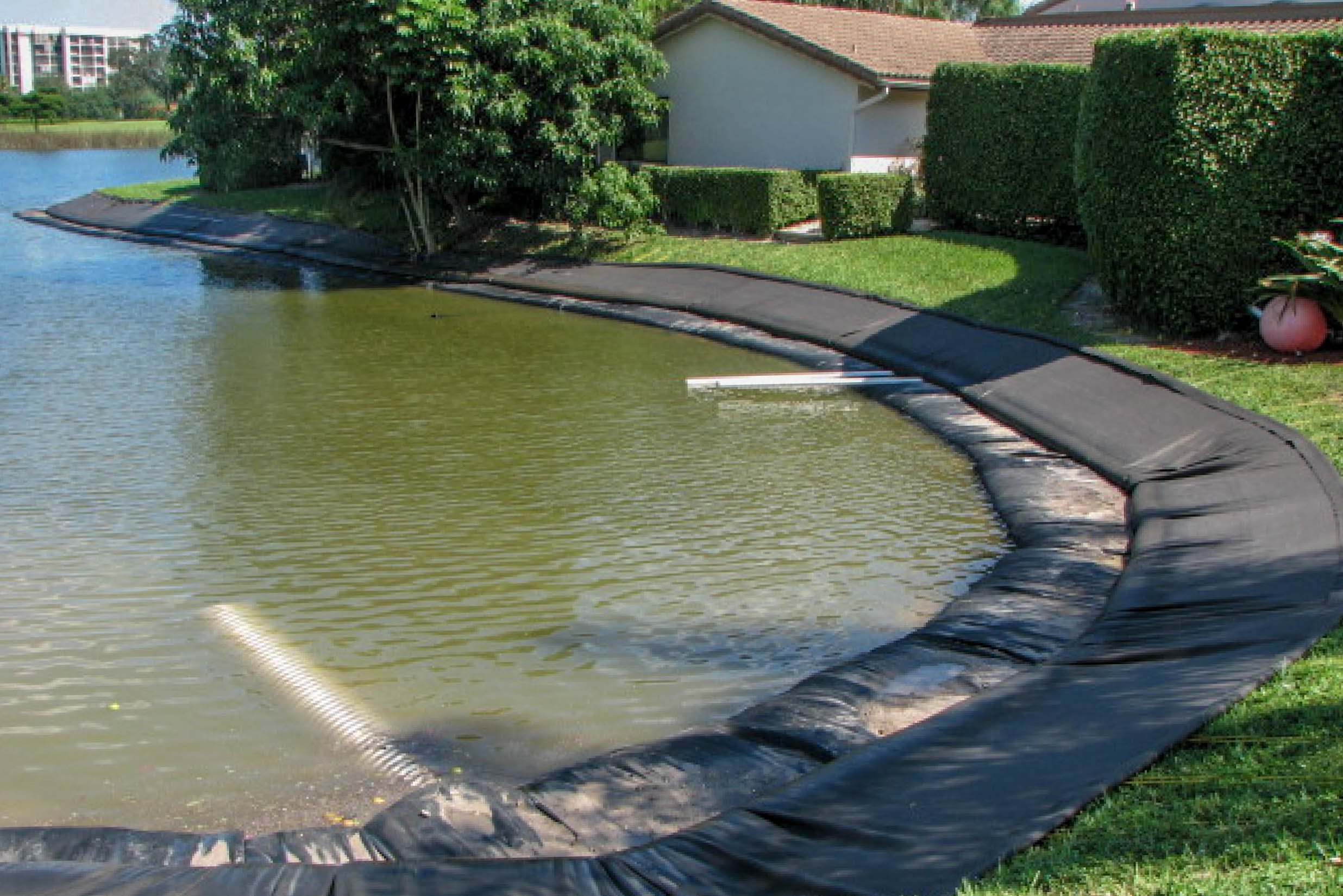 Geo Tube installation along a golf course pond with adjacent residence