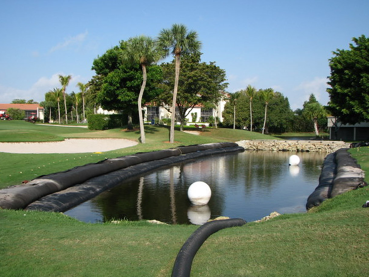 Geo Tube barriers lining a Yacht, Golf & Tennis pond during restoration