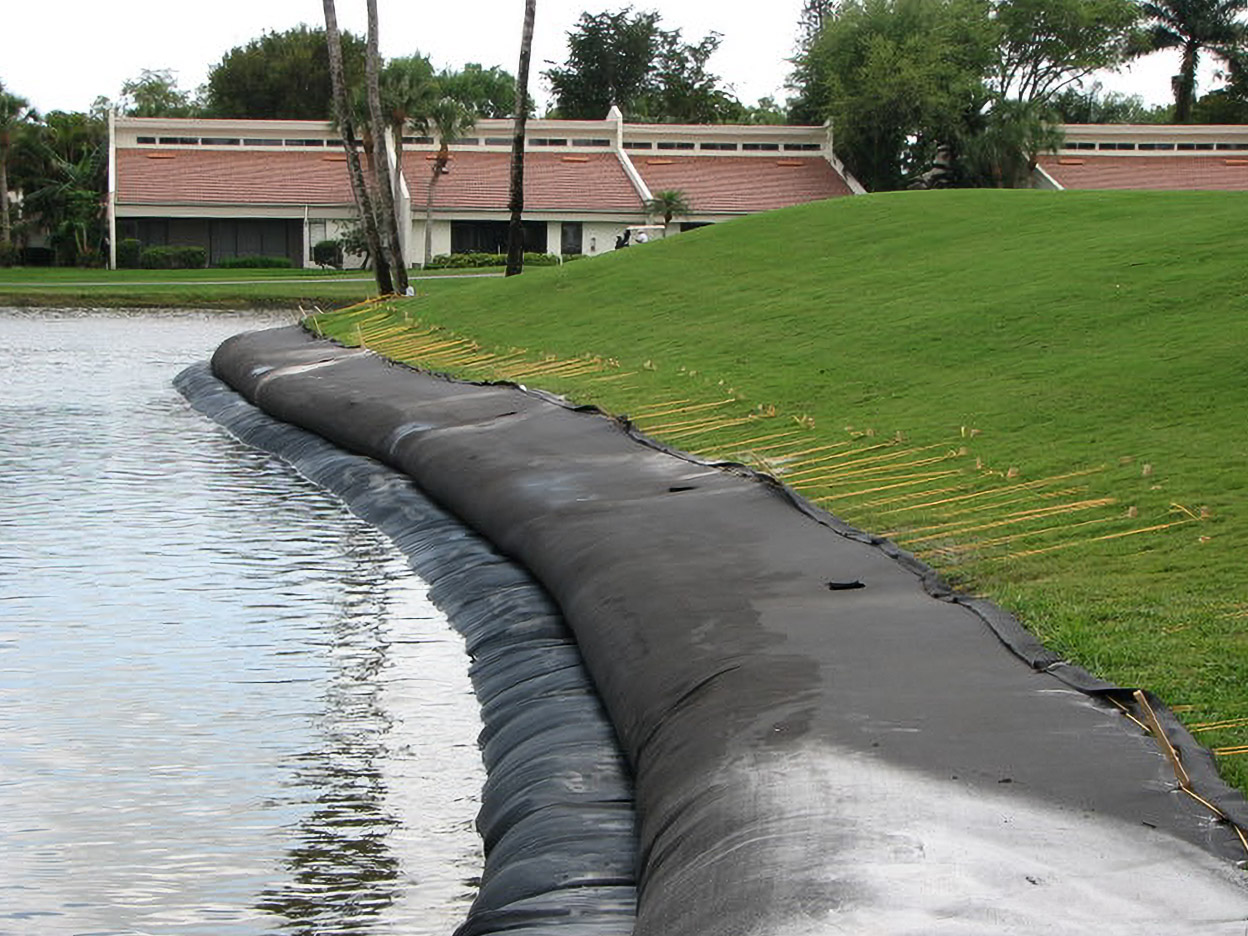 Geo Tube curving along a Yacht, Golf & Tennis pond bank during installation
