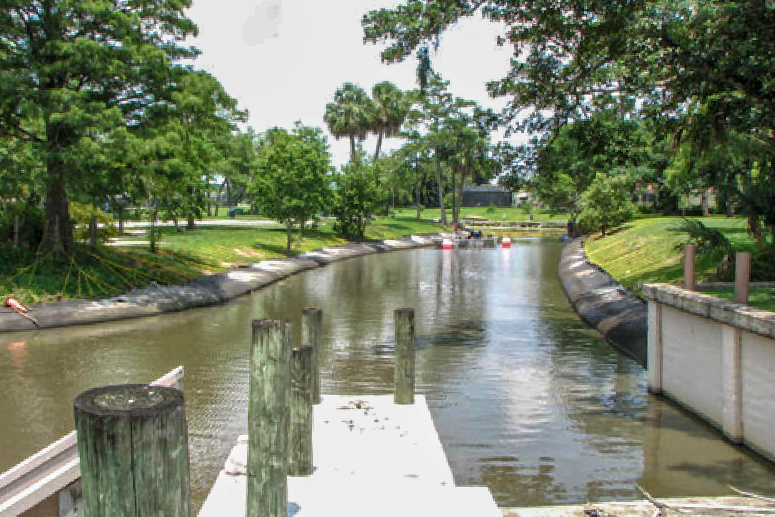 Calm municipal canal during restoration, with Geo Tube exposed along the bank