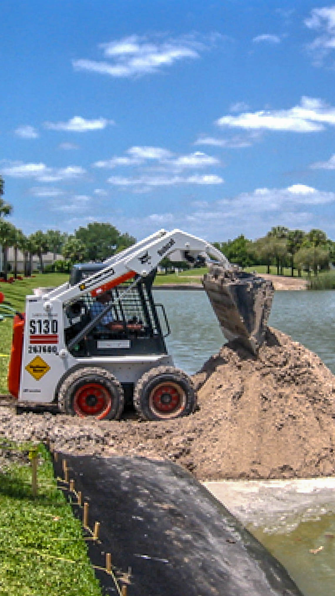 Bobcat skid-steer moving sand fill during a restoration project at The Villages