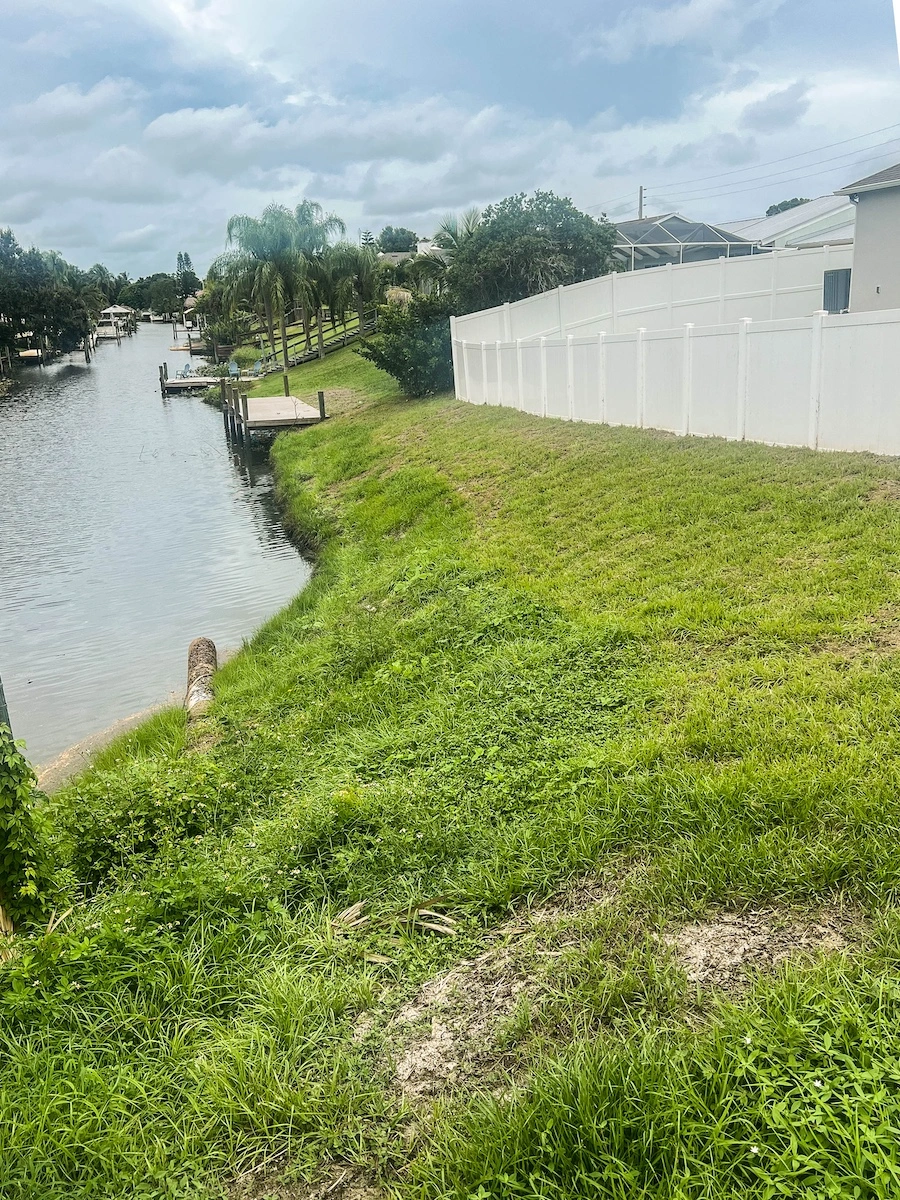 Restored canal bank with stabilized green slope after Geo Tube installation
