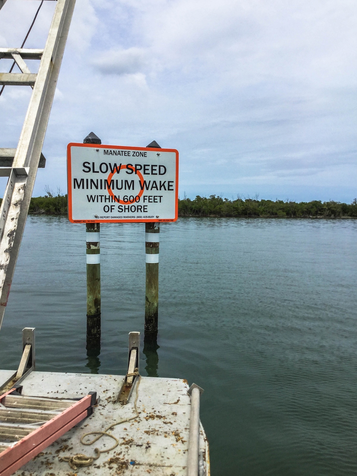 Manatee Zone slow-speed minimum-wake sign marking a Florida waterway adjacent to a marine construction project
